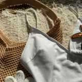 Detail of white star-patterned swimsuit with spaghetti straps and textured summer fabric