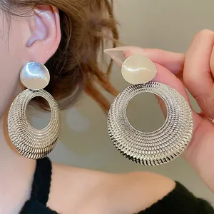 Boucles d'oreilles créoles argentées avec pendentifs ronds à texture alvéolée