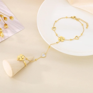 Detail of 18k gold stainless steel ring bracelet with clover and hollow heart charms