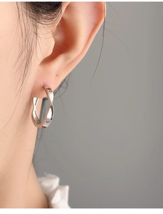 Close-up of minimalist silver twisted ear cuff on ear for a modern luxury look