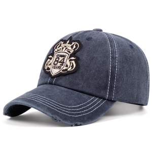 Détail de la casquette en jean bleu marine délavé avec écusson brodé style vintage 84 Years
