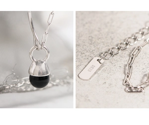 Detailed macro view of S925 silver necklace with black pendant and adjustable chain links