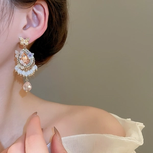 Close-up of vintage butterfly earrings with champagne crystal and beaded fringe