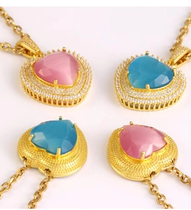 Macro detail of heart-shaped blue and pink topaz pendants with sparkling crystal borders