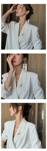Three-angle view of gold angel wing brooch with white crystals on a white blazer