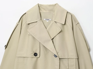 Close-up of khaki water-resistant short trench coat with label and button details