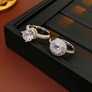 Elegant silver zircon rings with halo and twist band designs in a luxury gift box