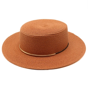 Dettaglio della trama in paglia con finiture in metallo dorato su un cappello boater a tesa