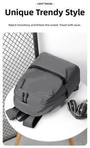 Side view of dark grey waterproof nylon business backpack on table with modern accessories