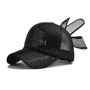 Détail de paillettes, lettre M en métal argenté et maille sur un chapeau de soleil