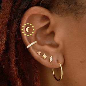 Close-up of gold S925 sterling silver ear set with moon, star and lightning studs