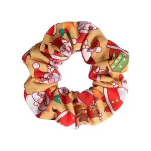 Detailed view of yellow Christmas scrunchie with Santa Claus and reindeer patterns