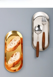 Detail display of oval stainless steel trays in gold and silver finish with smooth edges