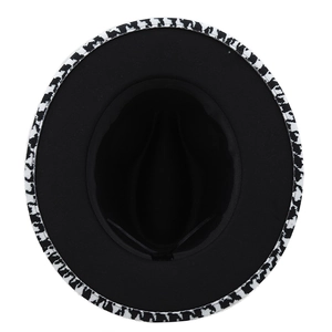 Flat lay of a black wool fedora hat with unique black and white patterned brim details