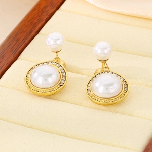 Gros plan de boucles d'oreilles perles dorées avec halo de cristal sur velours