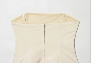 Dettaglio del top a fascia beige in tessuto di alta qualità con cerniera posteriore invisibile