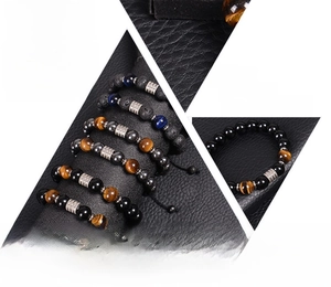Detailed view of natural tiger eye and obsidian bead bracelets on black leather texture
