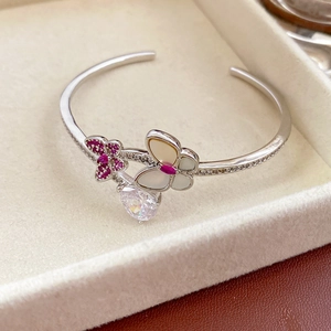 Detail of silver butterfly bangle featuring zircon drop pendant and mother of pearl