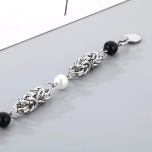 Detailed macro view of mixed pearl and silver chain links with black glossy beads