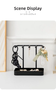 Detail of black iron jewelry organizer with four hooks and rectangular base tray