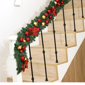 Detail of a 2.7m Christmas garland with red flowers and ornaments on a staircase