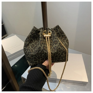 Primer plano de un bolso de mano chic con estampado de leopardo y una cadena dorada