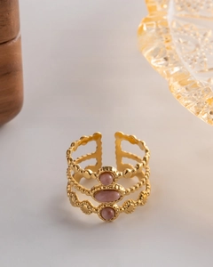 Detailed view of gold triple-band adjustable ring with three pink oval gemstones
