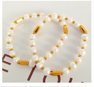 Macro view of natural freshwater pearls and golden metal tubes on a minimalist bracelet