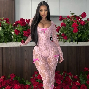 Pink lace long sleeve bodysuit with delicate bow accents in a floral setting