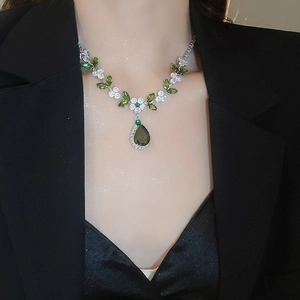 Dettaglio della collana con ciondolo a goccia in zircone verde e foglie d'argento