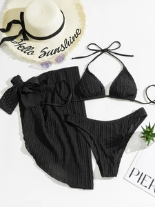 Detailansicht des schwarzen Bikini-Sets mit Ösenmuster, Plissee-Stoff und Strandrock