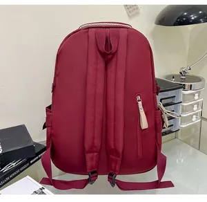 Detail of burgundy backpack back with padded straps and anti-theft zipper pocket