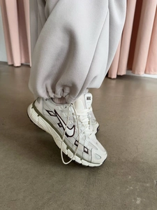 Close-up of Nike sneaker with ivory mesh and olive accents on a retro aesthetic trainer