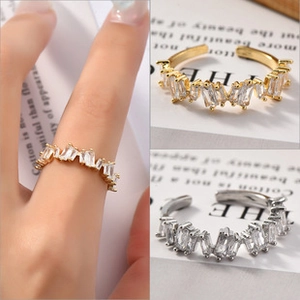 Detailed view of adjustable gold and silver rings set with rectangular cubic zirconia