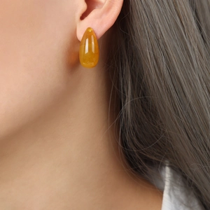 Bohemian vintage resin teardrop earrings in amber gold on a model side profile