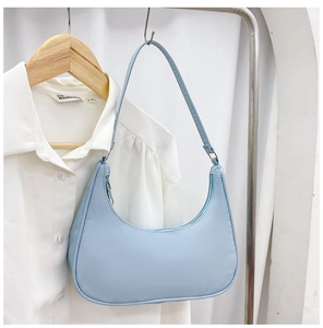 Detail of light blue nylon crescent bag with silver zipper and minimalist shoulder strap