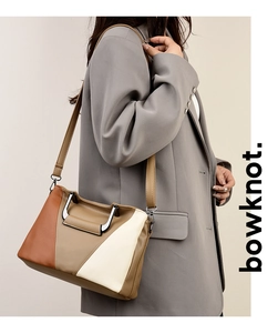 Detail of color-block tote bag with litchi texture leather and geometric metal handle