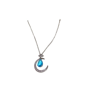 Silver moon necklace with blue teardrop gemstone and white zircon accents on white background