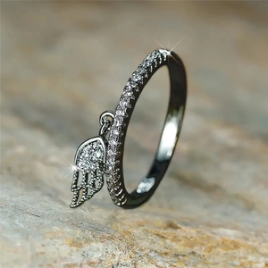 Black feathered wing ring with cubic zirconia pendant charm in a 45-degree macro view