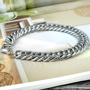 Polished silver titanium steel cuban link bracelet with lobster clasp on a magazine