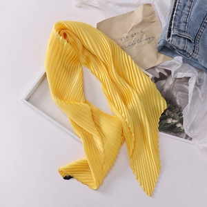 Detail shot of yellow pleated silk scarf texture and delicate overlock edge finish