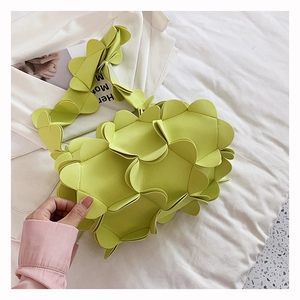 Macro shot of 3D layered petal design on neon green shoulder bag in soft leather