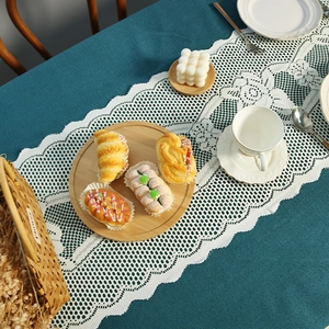 White lace table runner with wooden tray and bread models in a festive setting