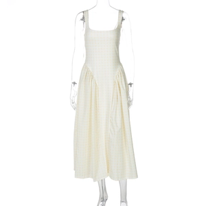 Close-up of light yellow and white plaid dress with square neckline and pleated skirt