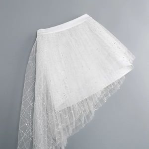 Detailed view of white mesh skirt with irregular hem and delicate sequin embellishments