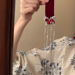Elegant butterfly hair clip with red crystals and long pearl tassels on velvet