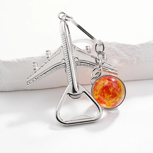 Detailed close-up of a silver airplane bottle opener with a decorative glass bead pendant