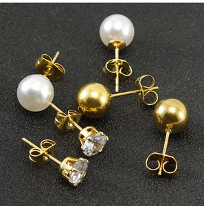 Primer plano de pendientes de oro de 18K con perlas, circonitas y bolas pulidas