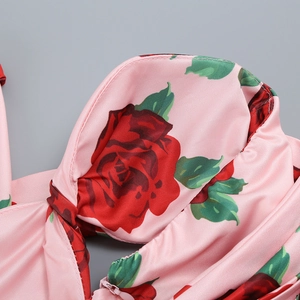 Macro detail of silky satin dress showing red rose print and hidden zipper seam