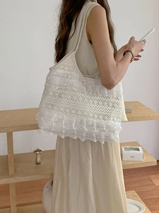 Detail of bohemian white crochet lace shoulder bag with layered ruffle design texture